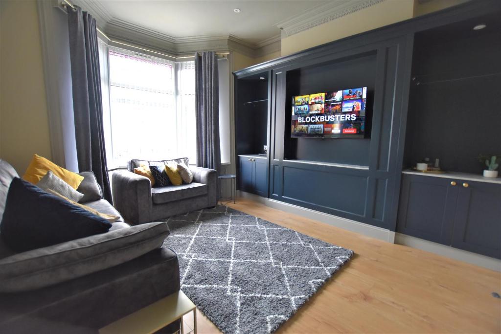 a living room with a couch and a tv at Central Cheerful Comfortable 3 Bedroom Home in Pallion