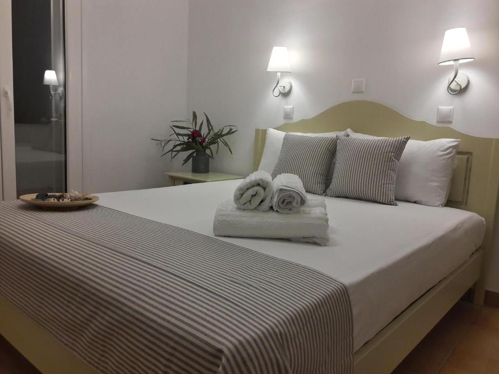 a bedroom with a large bed with towels on it at Stavento Apartments in Aliki