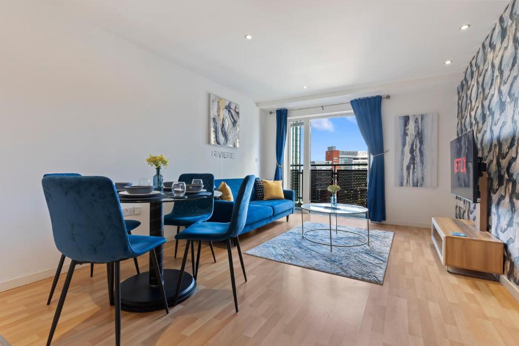 a living room with a blue couch and a table at Apartment-City Centre-Masshouse in Birmingham