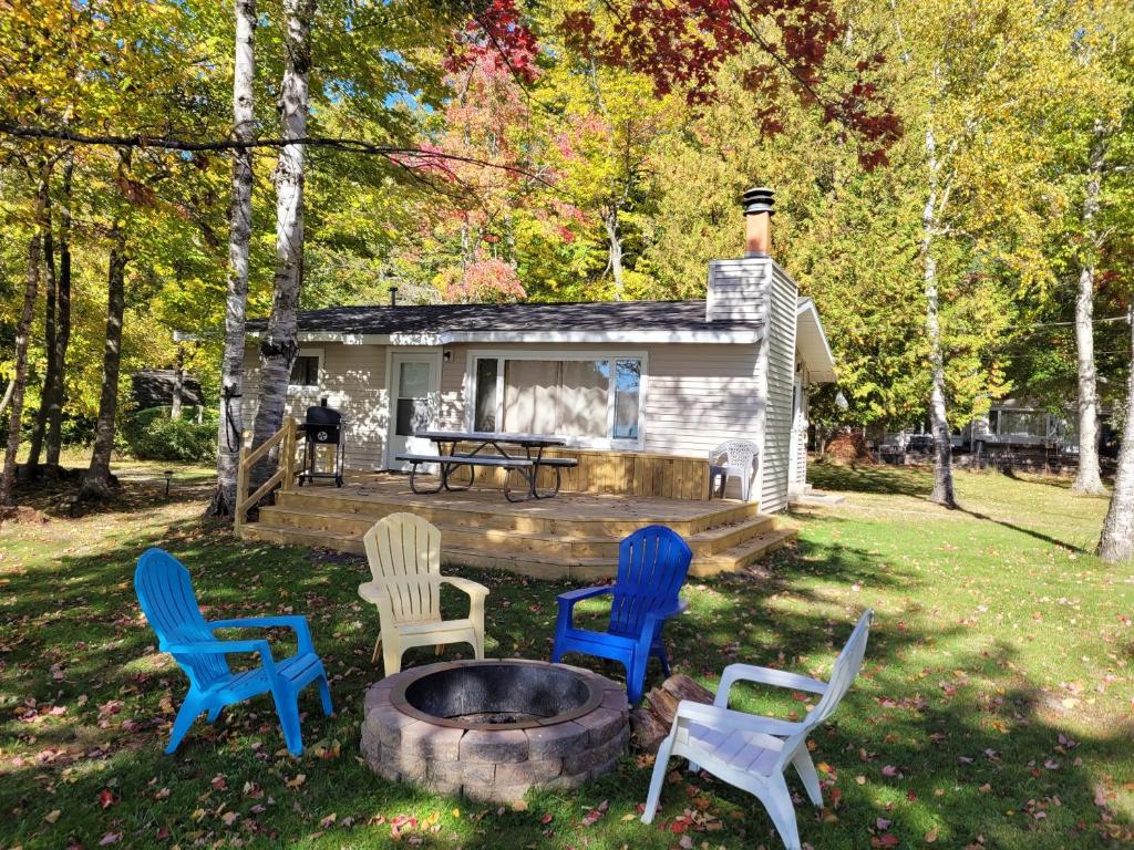 un gruppo di sedie seduti intorno a un focolare di Birch Shores Resort - The Hemlock Cottage a Empire