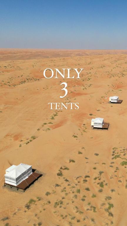 two beds in a desert with the words only tents at FYAFY Bidiyah Bedouin Camp in Bidiyah