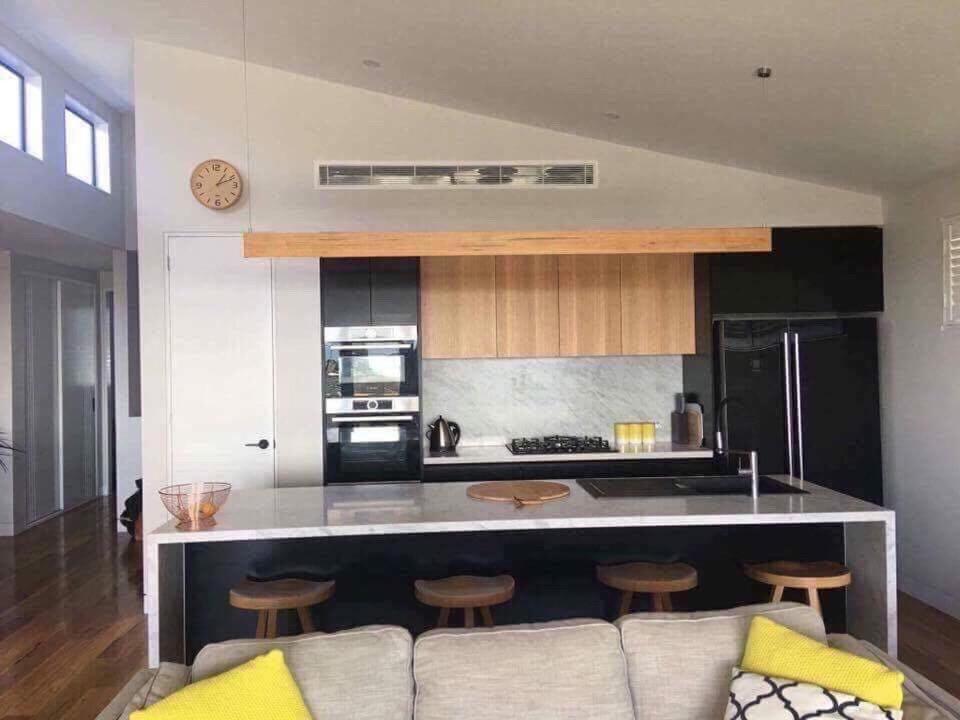 een woonkamer met een bank en een keuken bij Bayview Villa Portarlington in Portarlington