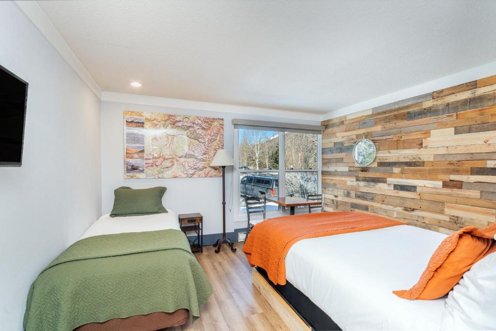 a bedroom with a bed and a wooden accent wall at Mountainside Inn 111 by Alpine Lodging Telluride in Telluride