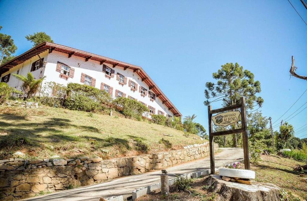 una señal frente a un edificio en una colina en Refúgio Alpino Economy, en Campos do Jordão