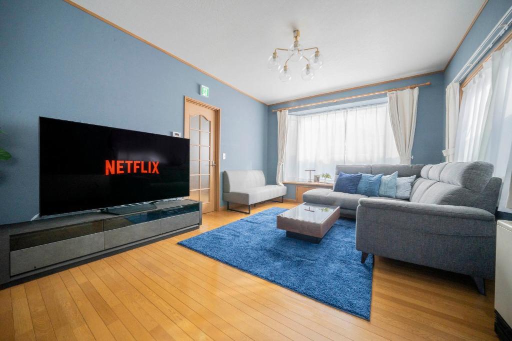 a living room with a couch and a tv at Torenia in Furano