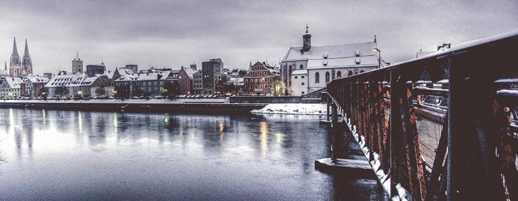a bridge over a river next to a city at Bohemian Hotel in Regensburg