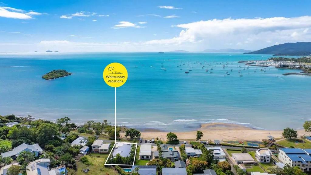 坎农代尔Whitsunday Escape - Beachfront with Private Pool的海滩的空中景色,带有黄色标志