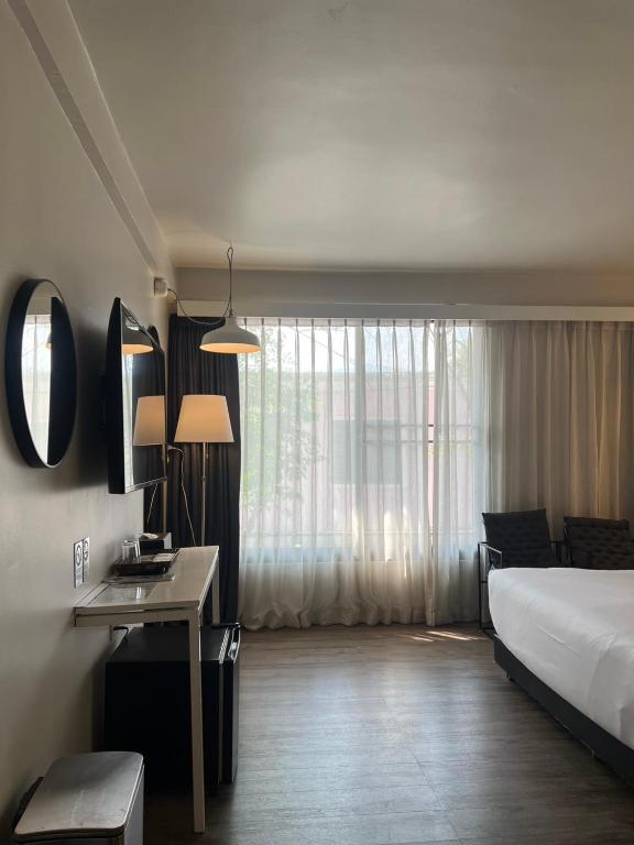 A streamlined room view showing the desk, illuminated vanity area, window and edge of the bed.