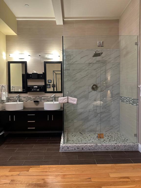 a bathroom with two sinks and a shower with two mirrors at Rio Vista Inn & Suites Santa Cruz in Santa Cruz
