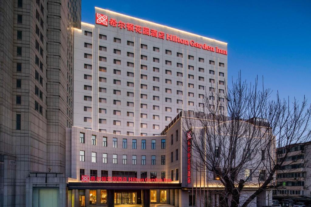un grande edificio con un cartello in cima di Hilton Garden Inn Tianjin Five Great Avenues a Tianjin