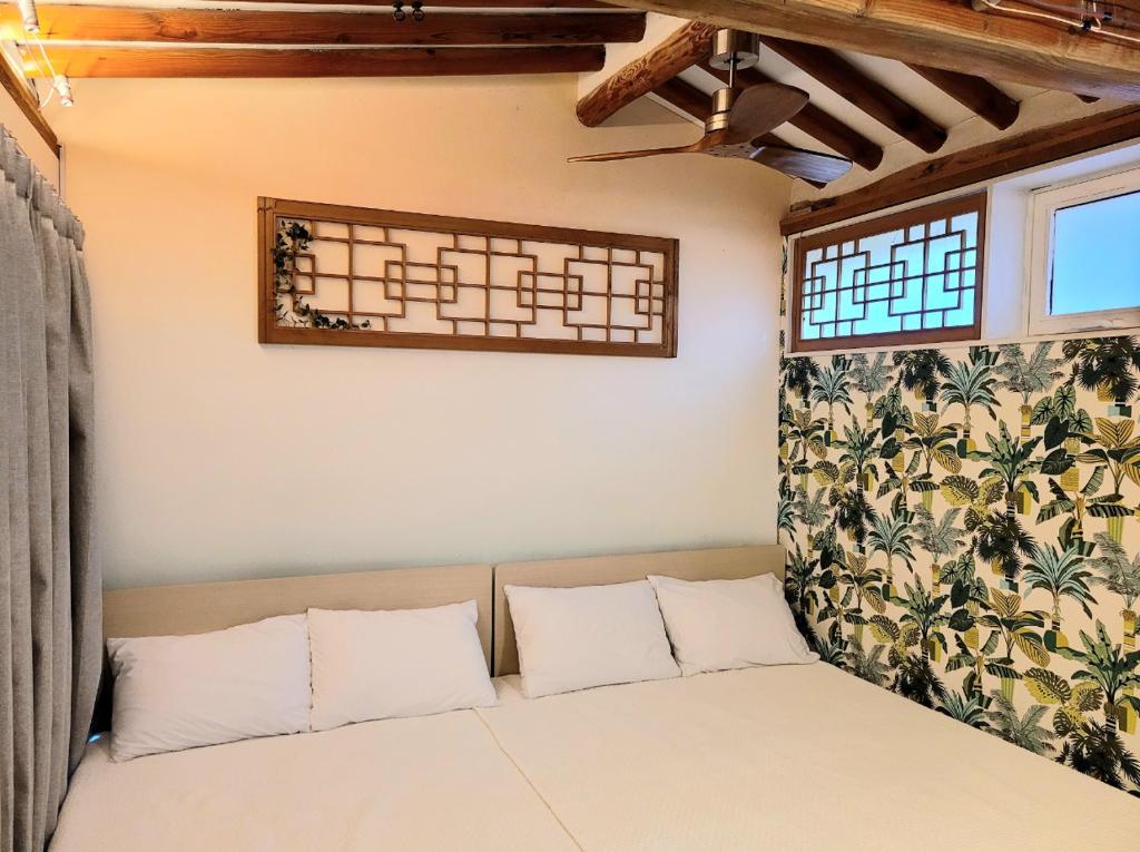 首尔'Hanok Hanok' Boutique stay Hotel Seoul - 2min from Gyeongbokgung Palace station的配有2扇窗户的客房内的1张床