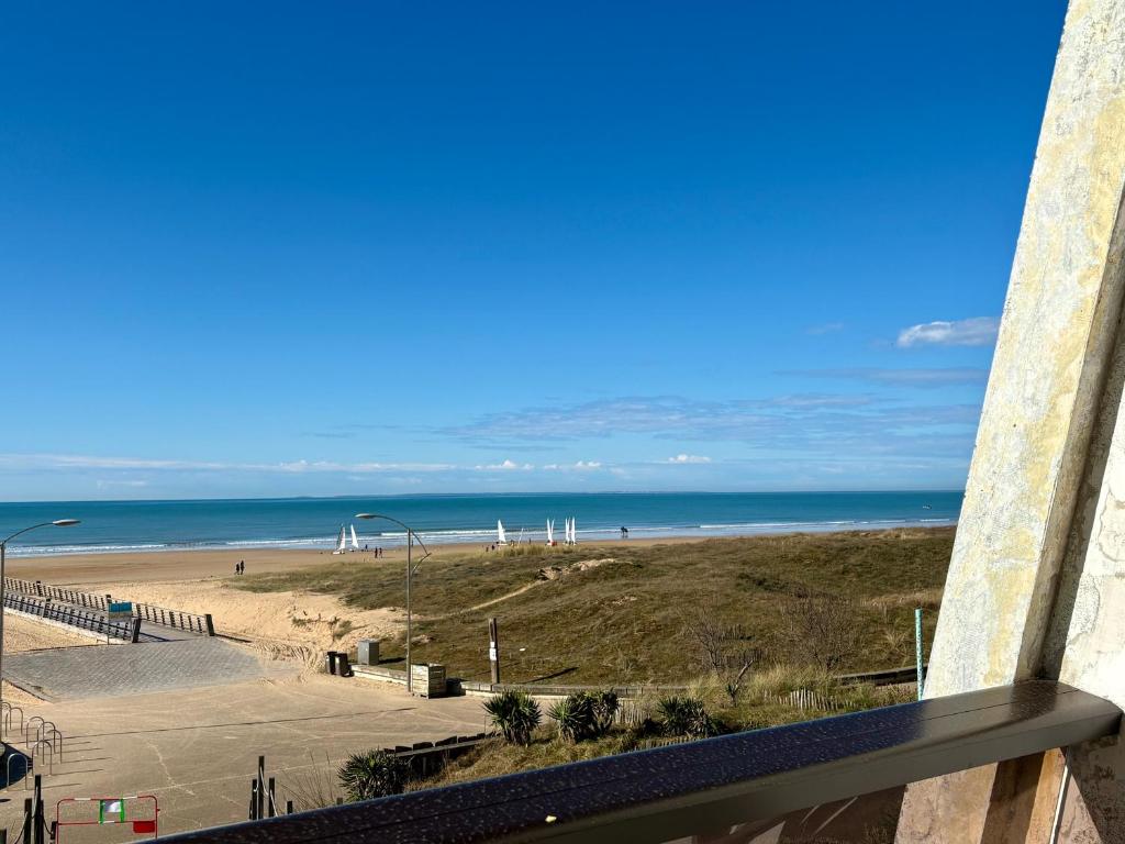 une vue sur une plage et l'océan depuis un immeuble dans l'établissement Studio rénové avec parking et animaux admis à Saint-Jean-de-Monts - FR-1-323-430, à Saint-Jean-de-Monts