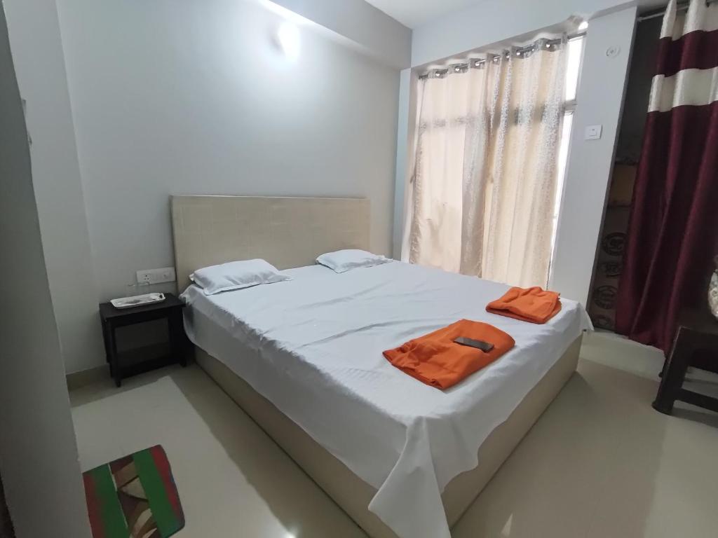 a bedroom with a bed with an orange towel on it at RAGHAV SADAN Luxury Apartment in Prayagraj