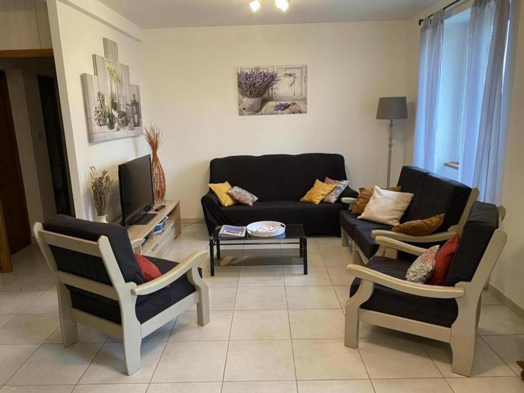 un salon avec un canapé et deux chaises dans l'établissement Maison de caractère en pierre, 7 km de Sarlat, avec terrasse, grand jardin et jeux pour enfants - FR-1-616-191, à Proissans