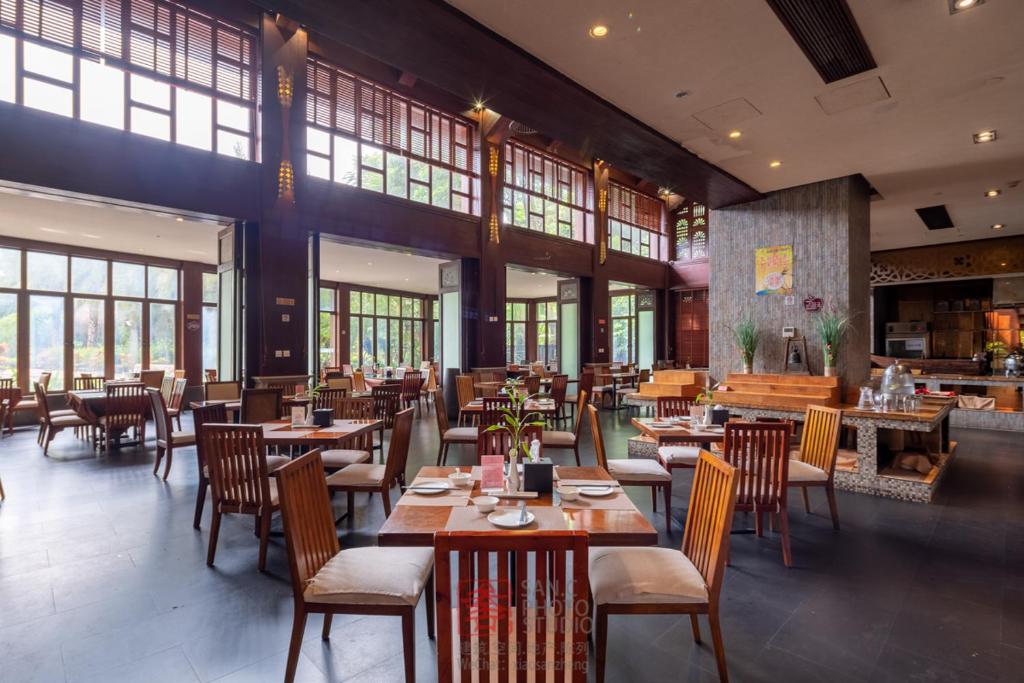 三亚Stony Brook Villa Jianguo Resort Sanya的餐厅设有木桌、椅子和窗户。