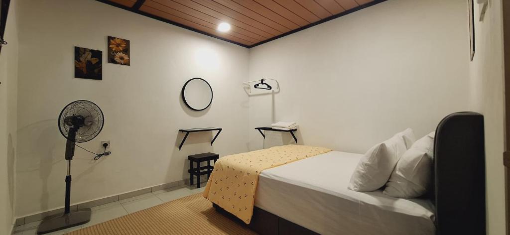 a bedroom with a bed and a fan in it at Ipoh Meru Landed Homestay TropiCasa 28 in Ipoh