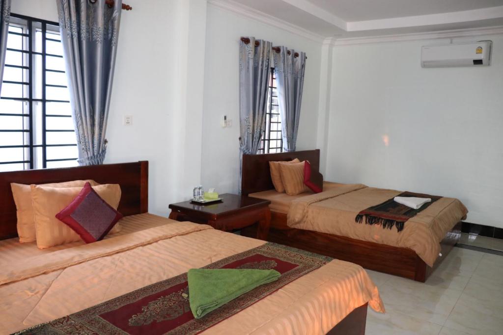 a hotel room with two beds and two windows at AHHA Bungalow Kampot in Kampot