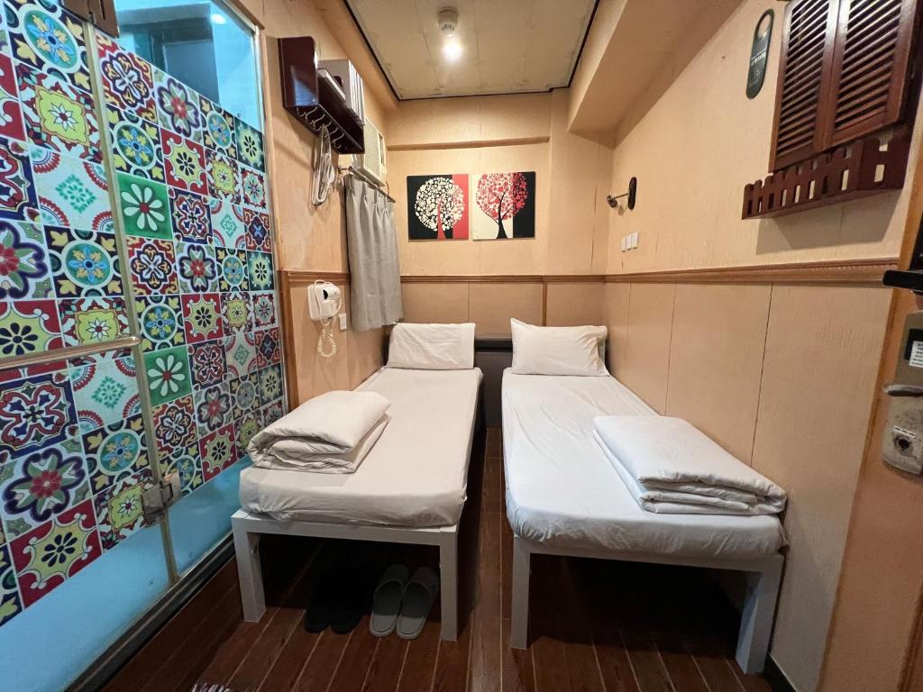 A bed or beds in a room at Just Inn on Nathan Road