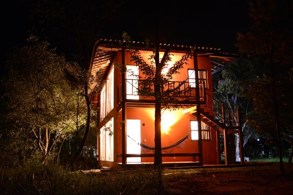 Una casa se ilumina por la noche en Pousada Rosa dos Ventos Capão, en Vale do Capao