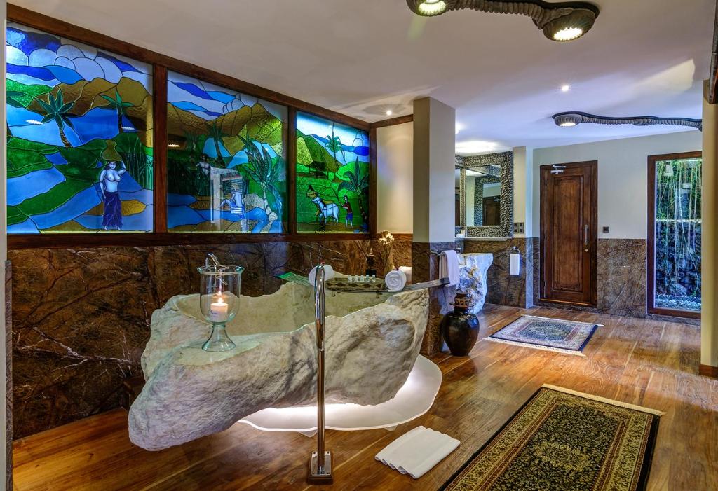 Un baño con bañera y vidriera. en Permata Ayung Private Estate, en Ubud