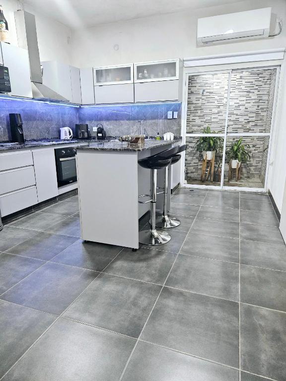 卡塔马卡Casa Valle Viejo con Cochera Cubierta Gratis的厨房配有白色橱柜和瓷砖地板