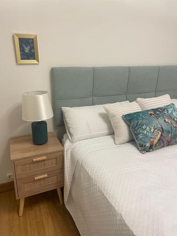 a bed with a blue headboard and a lamp on a night stand at Piso Turístico Navarrete in Navarrete