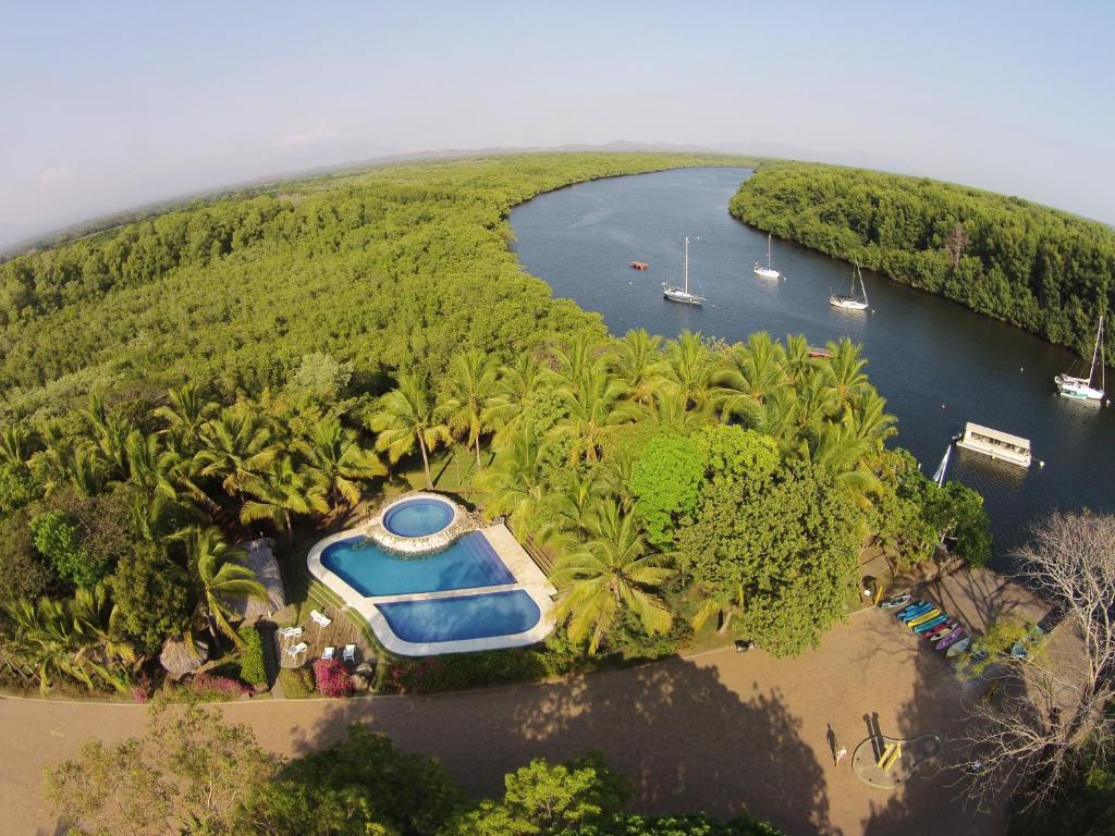 eine Insel mit einem Boot in der Mitte eines Flusses in der Unterkunft Puerto Barillas in Bahia de Jiquilisco