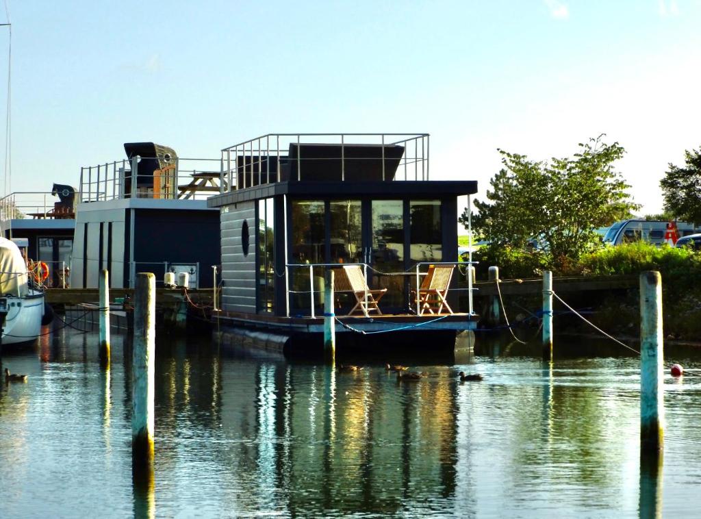 a house boat docked at a dock in the water at Floating freedom by the Dodekalitten in Torrig