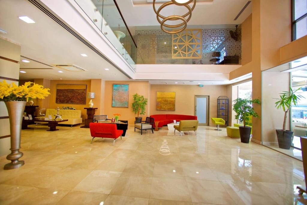 a lobby with chairs and tables in a building at Ramada By Wyndham İstanbul Taksim in Istanbul
