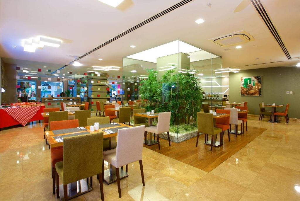 a restaurant with tables and chairs and a large window at Ramada By Wyndham İstanbul Taksim in Istanbul