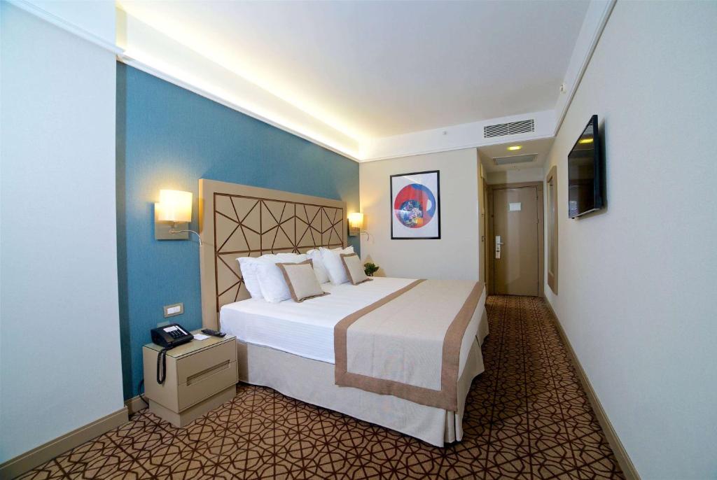 a hotel room with a large bed and a television at Ramada By Wyndham İstanbul Taksim in Istanbul