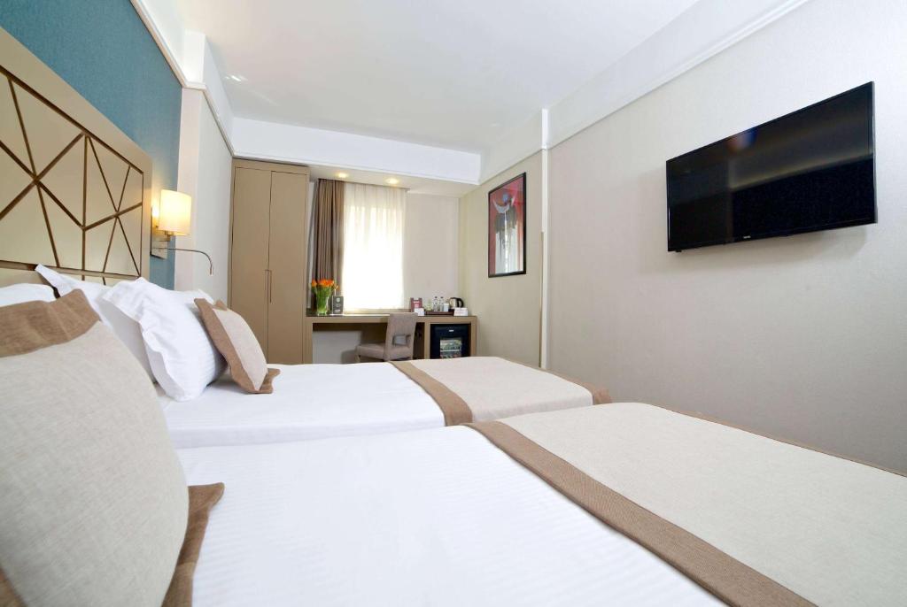 a hotel room with two beds and a flat screen tv at Ramada By Wyndham İstanbul Taksim in Istanbul