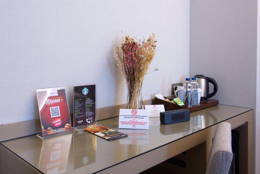a glass table with a vase of flowers on it at Ramada By Wyndham İstanbul Taksim in Istanbul