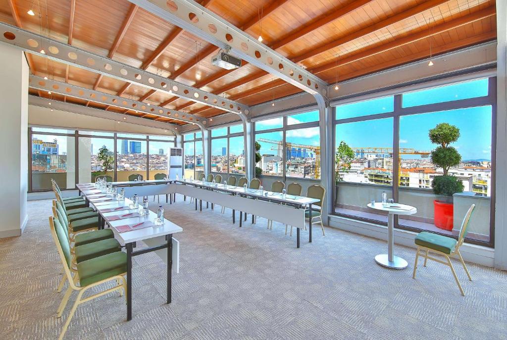 a large room with tables and chairs and windows at Ramada By Wyndham İstanbul Taksim in Istanbul