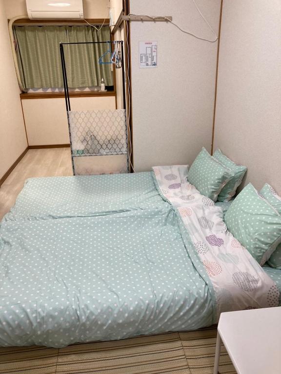 Postel nebo postele na pokoji v ubytování 大阪三姐妹天下茶屋館 Three Sisters Lodge -Tengachaya