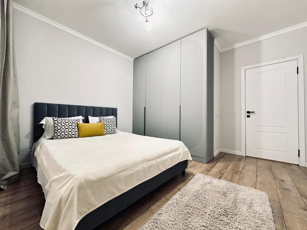 a bedroom with a large bed and a closet at Ala Park apartment in Almaty