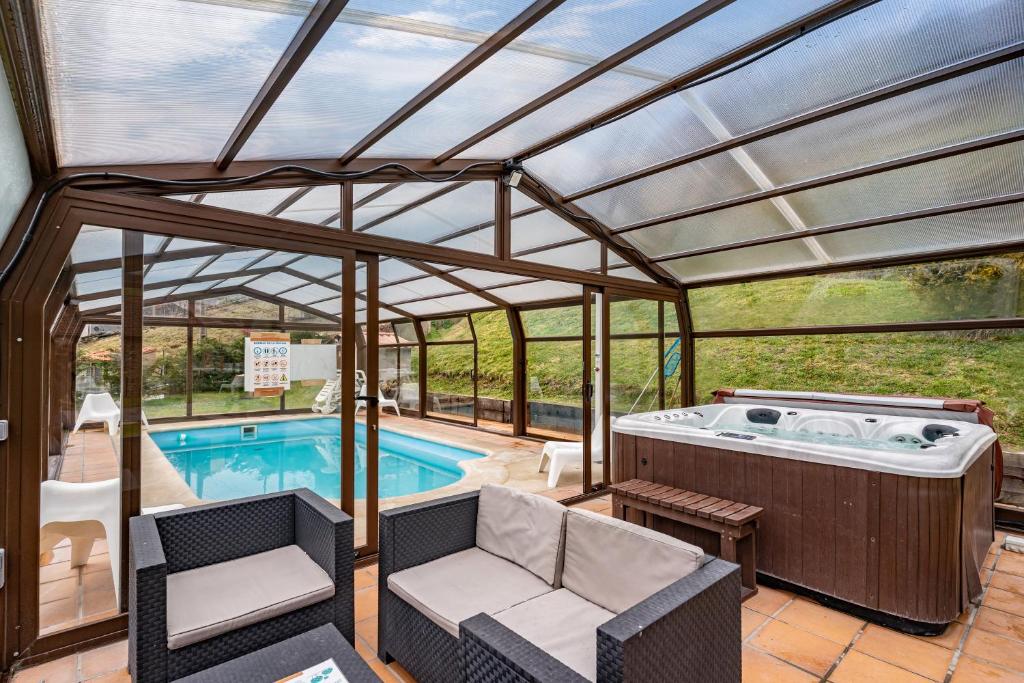 Una casa de piscina con jacuzzi y patio. en La Cerra, en Pajares