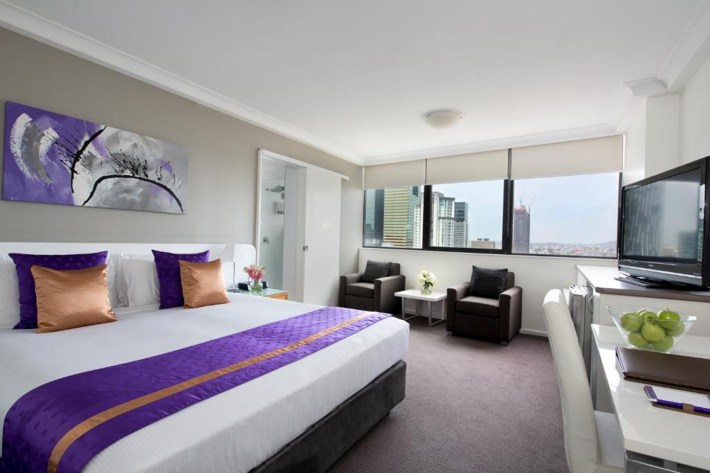 a hotel room with a bed and a flat screen tv at Park Regis North Quay in Brisbane