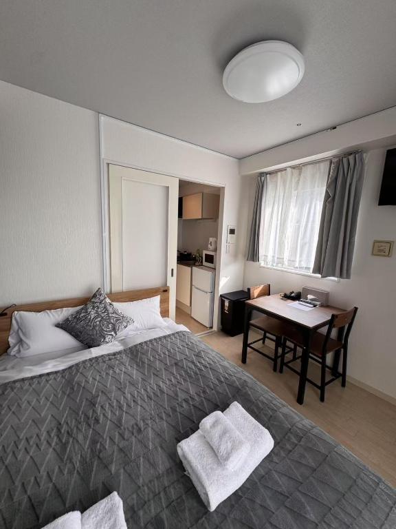 una camera da letto con un grande letto e un tavolo di PLy ad Osaka