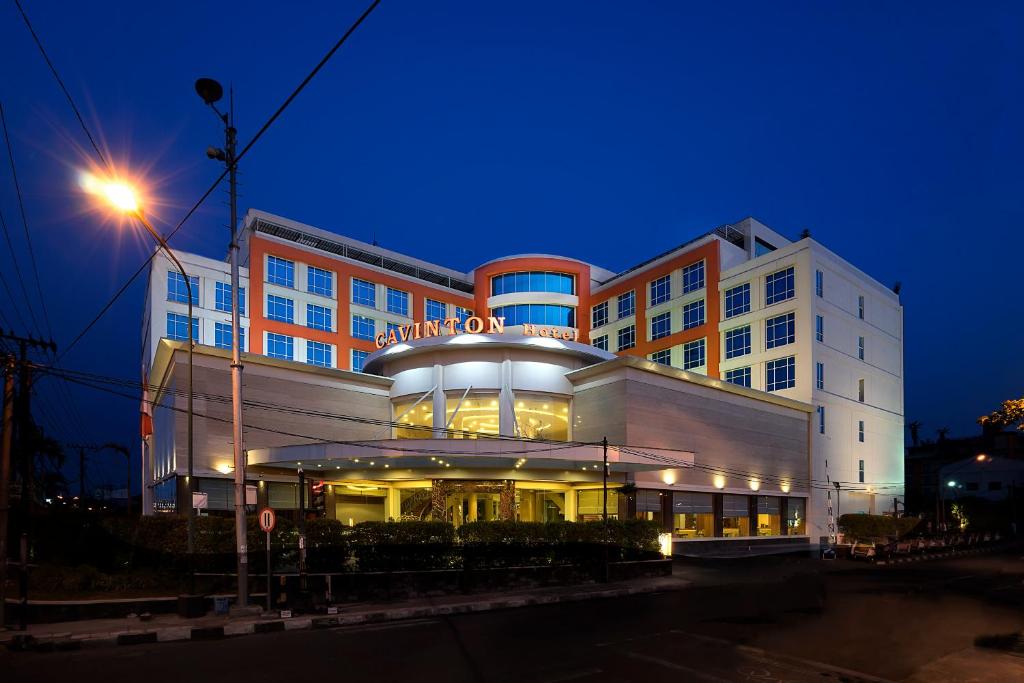 a building with a sign on top of it at night at Cavinton Hotel Malioboro Yogyakarta by Tritama Hospitality in Yogyakarta