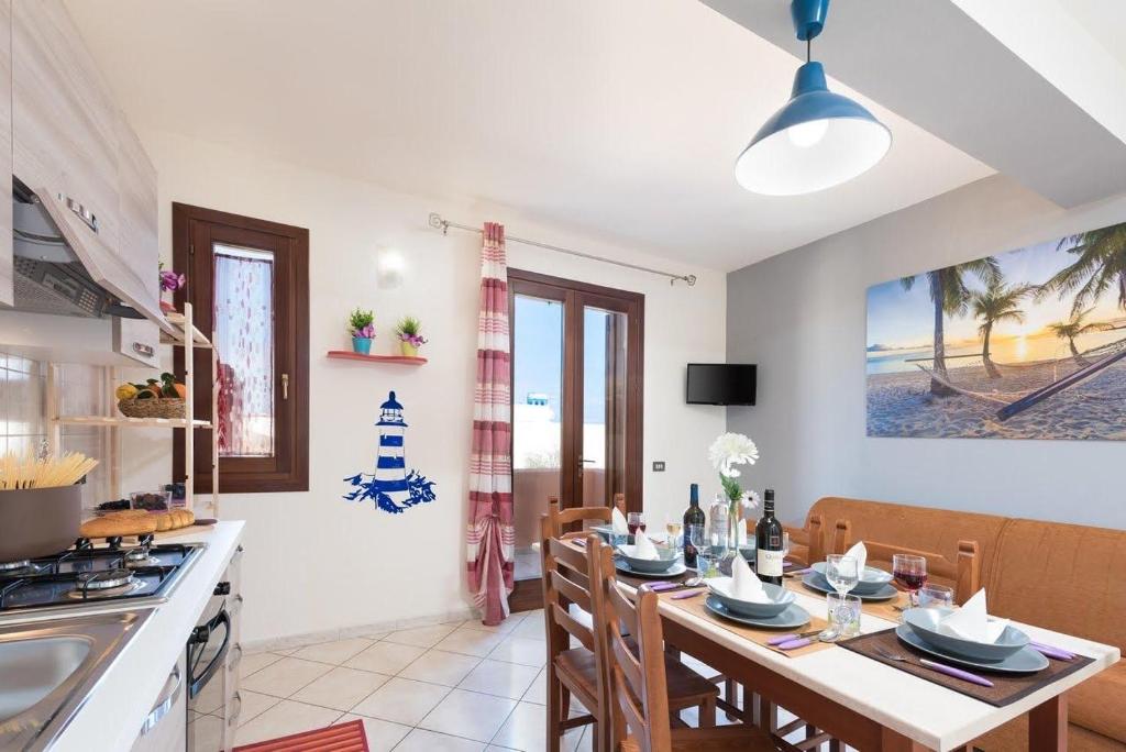 una cucina e una sala da pranzo con tavolo e sedie di Sea and sand Apartment a San Vito lo Capo