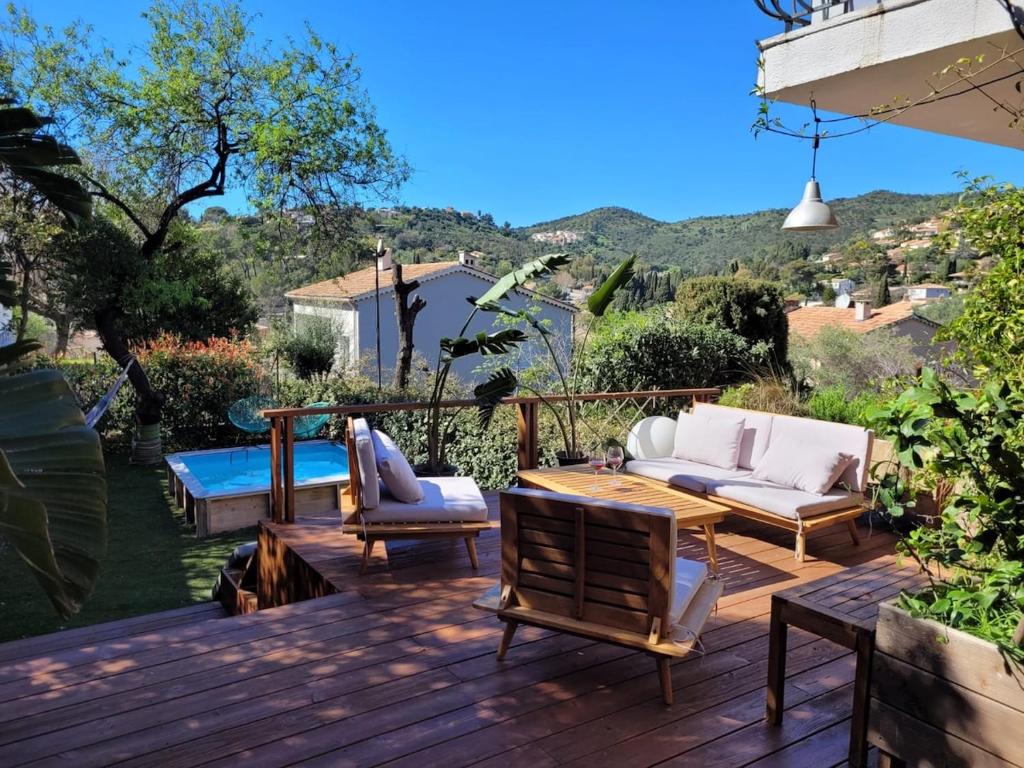 une terrasse en bois avec des canapés et une table dans l'établissement Spacieux t3 jardin et piscine, à Hyères