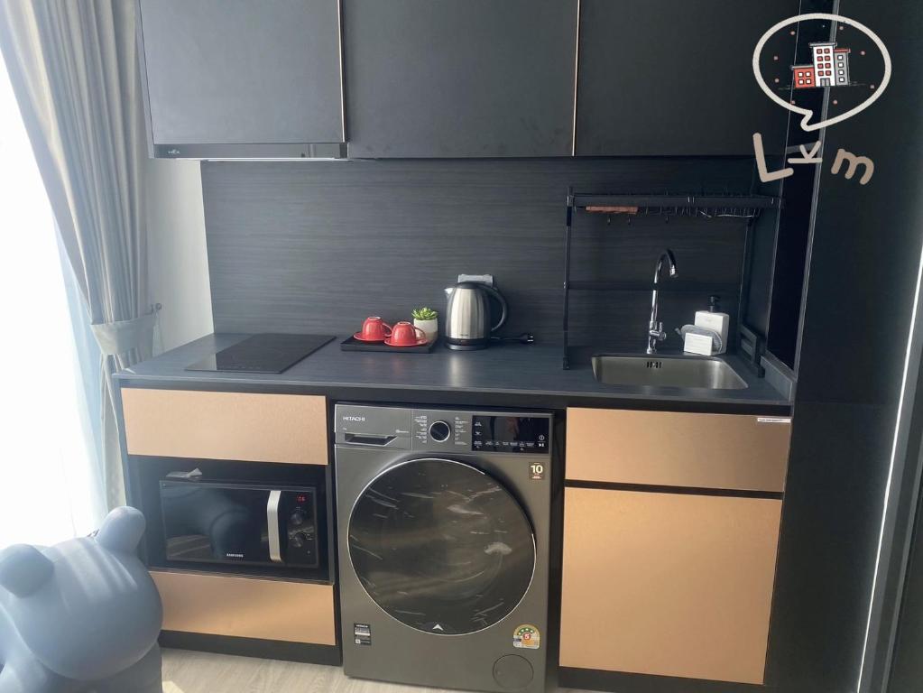 eine kleine Küche mit einer Waschmaschine und einem Waschbecken in der Unterkunft The Edge Central Pattaya High Floor, Pattaya City in Pattaya