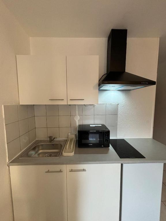 une petite cuisine avec un évier et un micro-ondes dans l'établissement Foch 3-Studio-Beziers center -wifi -tv connected, à Béziers