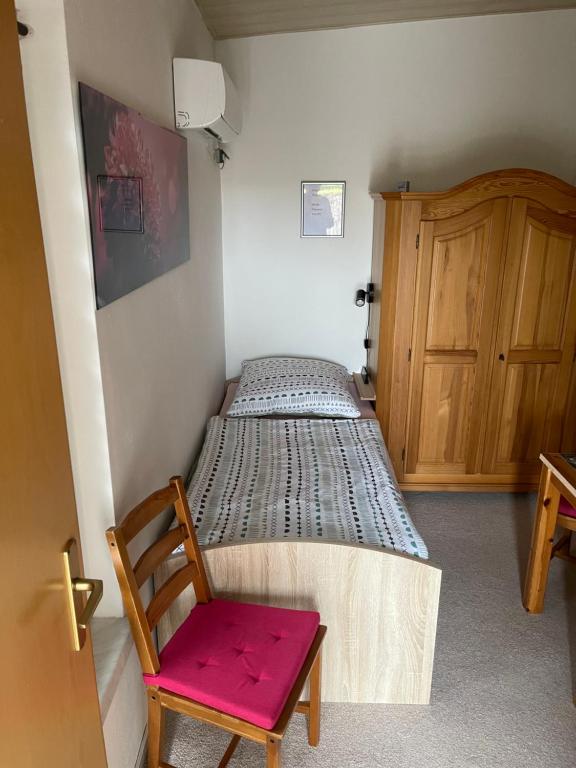 a small bedroom with a bed and a wooden cabinet at Zimmervermietung Ausspannen bei Fam Pertiller in Breese