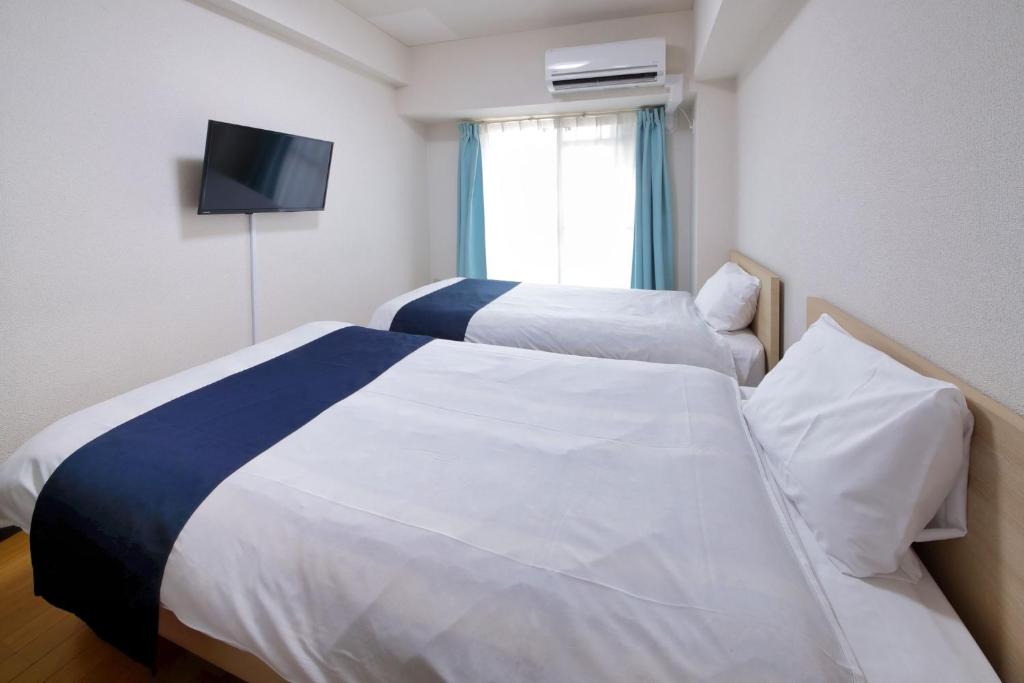 さいたま市にあるHOTEL Nishikawaguchi Weekly - Vacation STAY 43465vのベッド2台と薄型テレビ付きのホテルの部屋