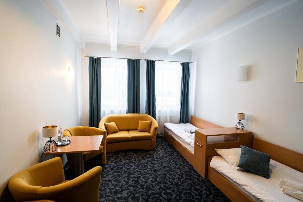 ein Hotelzimmer mit einem Bett, einem Stuhl und einem Tisch in der Unterkunft Hotel SANVIT RESTAURACJA & SPA in Sanok