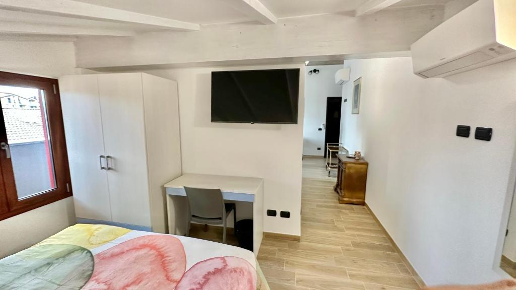 a bedroom with a bed and a desk and a television at A7 Moonlight FIERA-RHO-Mi-EXPO-MXP AMPIO&LUMINOSO MONOLOCALE in Cesate