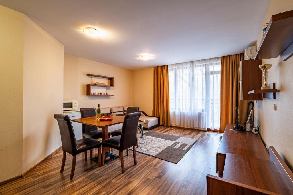 Una sala de estar con mesa de comedor y sillas. en Primrose Apartment with Free Parking, en Varna