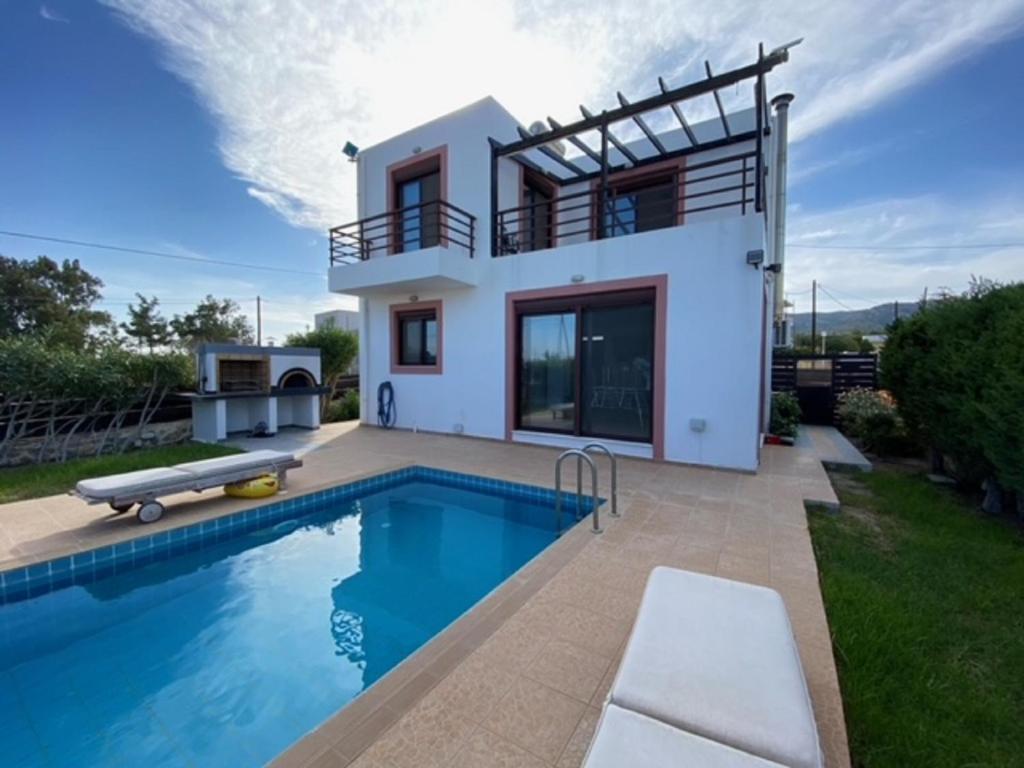 una villa con piscina di fronte a una casa di Gennadi Sunset Villa a Gennadi